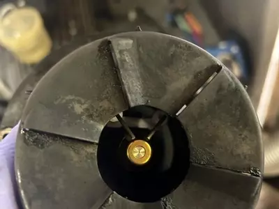 Close-up of cleaned burner nozzle and electrodes after servicing on a Nilfisk SH Truck Booster, showing improved condition for efficient combustion.